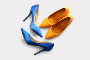 Stylish high heeled shoes on light background, top view