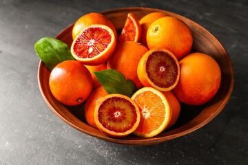 Bowl with delicious blood orange fruits on black grunge table