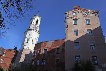 Clock tower in Vyborg, Russia. Cityscape with old stone houses in the historic center.