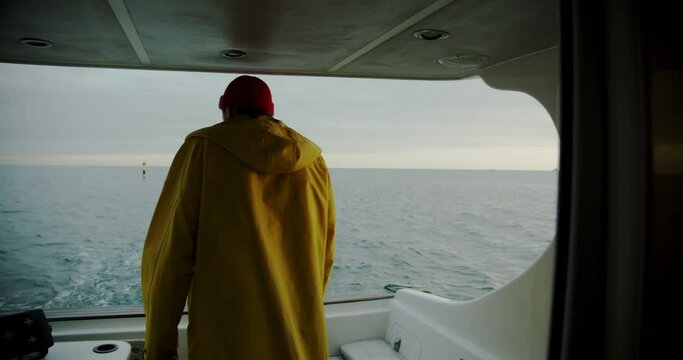 a fisherman stands on a boat and looks out to sea