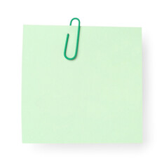 Green sticky note with paper clip on white background