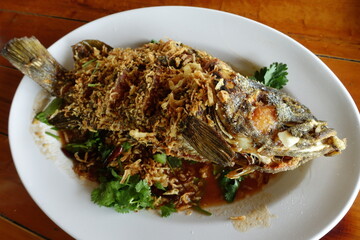 Fried sea bass with three flavors in a white plate