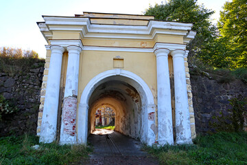 Fototapeta na wymiar Stone roadway and old gate near the city of Vyborg, Russia. Bright autumn landscapes of popular tourist destination and landmark.
