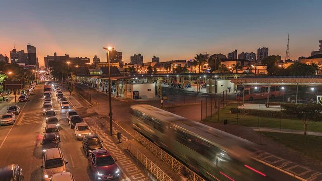 Avenue with car traffic, downtown terminal with movement of buses and people, Ponta Grossa city, Brazil