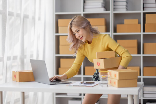 Portrait of Asian young woman SME working with a box at home the workplace.start-up small business owner, small business entrepreneur SME or freelance business online and delivery concept.
