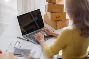 Portrait of Asian young woman SME working with a box at home the workplace.start-up small business owner, small business entrepreneur SME or freelance business online and delivery concept.
