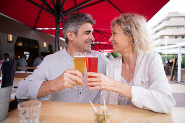 a portrait of a middle aged couple having a beer