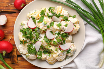 Plate of tasty Potato Salad with greens and radish on table