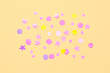 Composition with confetti and stars on yellow background