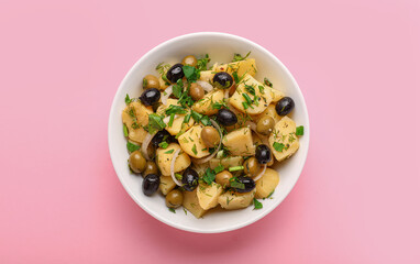 Bowl of tasty Potato Salad with vegetables on pink background