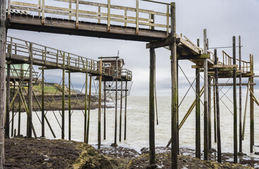 Fishermen's hut made of wood and resting on piles along the Atlantic ocean's coastline during a cloudy day