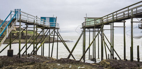 Fishermen's hut made of wood and resting on piles along the Atlantic ocean's coastline during a cloudy day