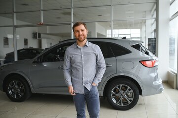Fototapeta na wymiar Young man is choosing a new vehicle in car dealership.