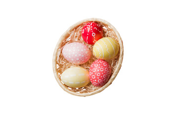 Basket of colorful Easter eggs isolated on white background. Easter basket filled with colored eggs top view holiday concept