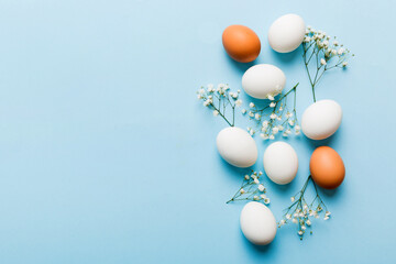Happy Easter composition. Easter eggs on colored table with gypsophila. Natural dyed colorful eggs background top view with copy space