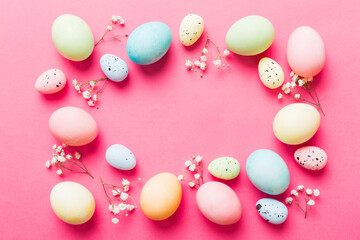 Happy Easter composition. Easter eggs on colored table with gypsophila. Natural dyed colorful eggs background top view with copy space