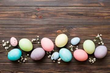 Happy Easter composition. Easter eggs on colored table with gypsophila. Natural dyed colorful eggs background top view with copy space