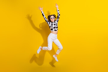 Full size photo of youth lady jumping enjoy her cowgirl look wearing black spotted clothes isolated shine color background