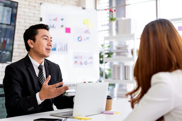 Professional Asian business adviser meeting to analyze and discuss the strategy of financial support of a tech company. Partnership start-up consultant.