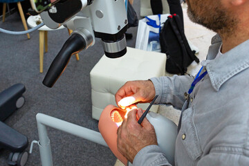 A dentist learns to work with a dental microscope. A dentist tests an endodontic microscope in a...