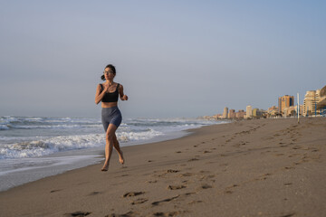 beautiful young girl running in the morning on the beach