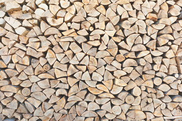 Neatly stacked firewood as a background, texture, pattern. Harvesting firewood for the winter.