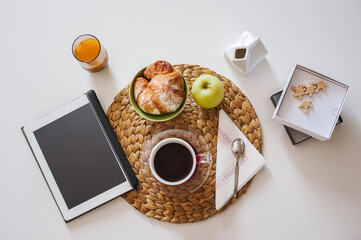 Breaksfast table with coffee, food and digitl tablet for news - 589813367
