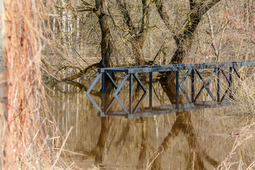 Flooded pedestrian metal bridge during the spring flood