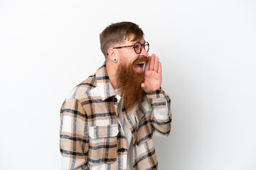 Obraz premium Redhead man with long beard isolated on white background shouting with mouth wide open to the side