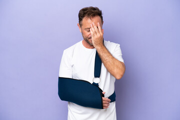 Middle age caucasian man with broken arm and wearing a sling isolated on purple background with tired and sick expression