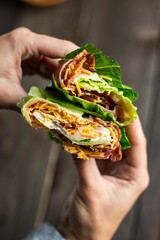 High angle closeup of hands holding a lettuce wrap
