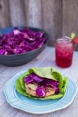 Vertical shot of a lettuce wrap with grilled chicken and cabbage on a plate
