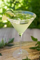 Vertical closeup shot of the glass of Margarita with mint and lime decorated with mint leaves