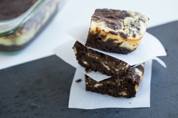 Closeup of the square cut cookies stacked on top of each other near the glass container