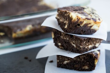 Closeup of the square cut cookies stacked on top of each other near the glass container