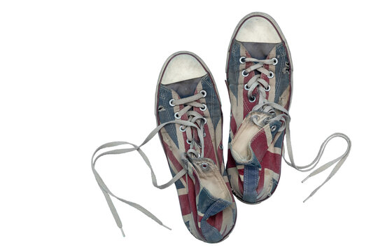 Pair of worn vintage canvas sneakers Converse with scuffed toes, faded print and untied laces, cut out on clean transparent background. Casual streetwear footwear element for youth fashion design