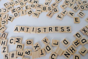 close-up wooden alphabet blocks on white background, word antistress, concept transient negative...