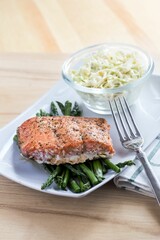 High-angle of salmon and asparagus with a salad put on the white table at a restaurant