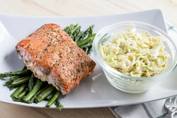 High-angle of salmon and asparagus with a salad put on the white table at a restaurant