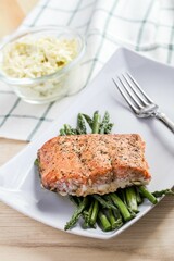 High-angle of salmon and asparagus with a salad put on the white table at a restaurant