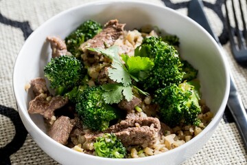 Closeup shot of a healthy dish with meat and broccoli in the white bowl