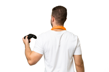 Young handsome man playing with a video game controller isolated on green chroma background in back position