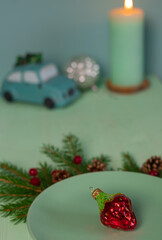 New Year's tea party at the table with a teapot, candles, cookies and fir branches