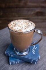 Closeup shot of a glass cup of mocha milkshake topped with whipped cream on the table