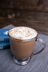 Closeup shot of a glass cup of mocha milkshake topped with whipped cream on the table