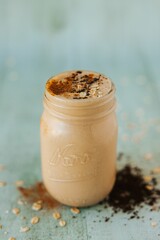 Closeup shot of a glass jar of mocha milkshake topped with cinnamon and cocoa powders