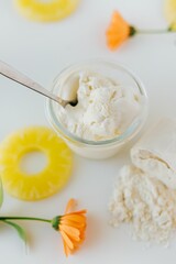 Vertical top view of a glass of ice cream surrounded by sliced pineapples