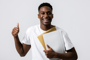 Cheerful handsome african american black man guy holding folder in hands showing thumb up at camera...