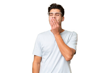 Young caucasian handsome man over isolated background yawning and covering wide open mouth with hand