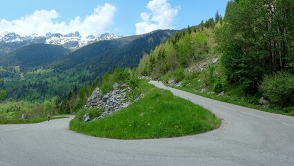 Alpen in Frankreich - Route des Grandes Alpes mit Rennradfahrer in Kurve Serpentinenstrasse